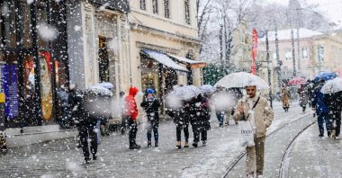 People walk along Istiklal Street as snow falls, Istanbul, Türkiye, Feb. 19, 2025. (AFP Photo)
