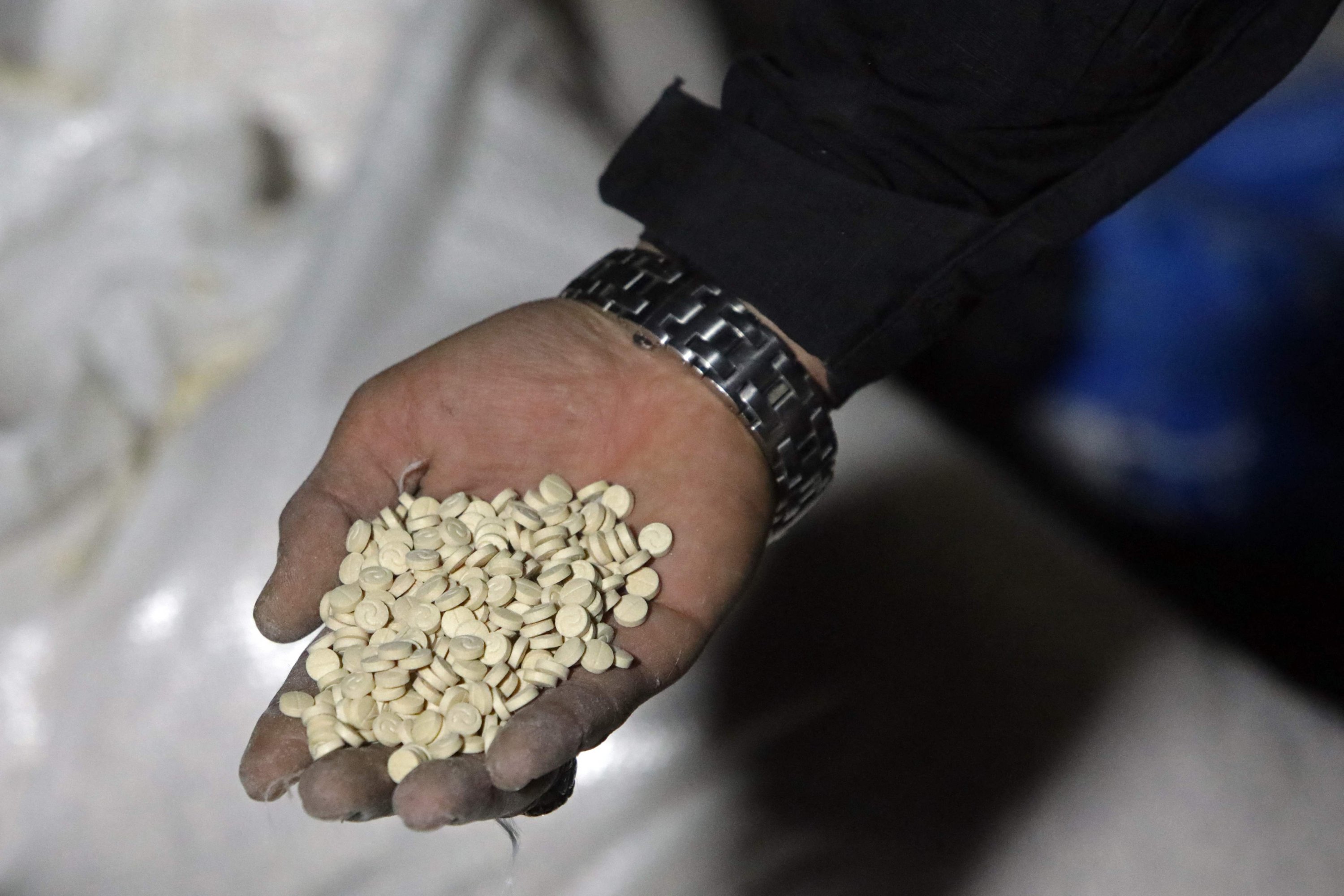 A member of the security forces of the new Syrian authorities shows Captagon pills found in a compound of the ousted regime leader Bashar Assad's forces, Damascus, Syria, Jan. 7, 2025. (AFP Photo)