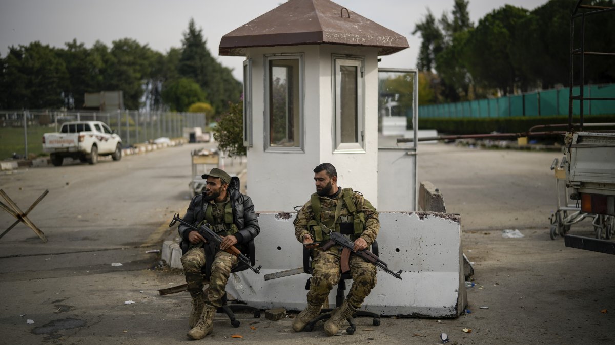 Syrian rebels guard the entrance of the Lakatia civilian airport located in the town of Hmeimim, southeast of Latakia, Syria, Dec. 16, 2024. (AP Photo)