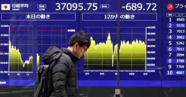 A passerby walks past a stock market indicator board in Tokyo, Japan, March 4, 2025. (EPA Photo)