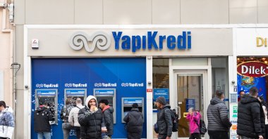 People walk past a Yapı Kredi Bank branch on a busy shopping street, central Istanbul, Türkiye, Jan. 7, 2025. (Reuters Photo)