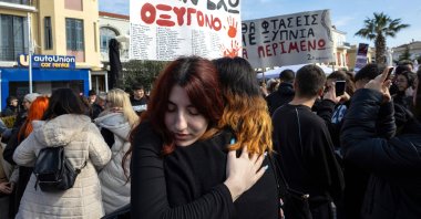Protesters embrace next to a placard to demand justice for the victims of a train crash, Lesvos island, Greece, Feb. 28, 2025. (EPA Photo)