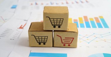 Shopping cart box representation over a business graph. (Shutterstock Photo)
