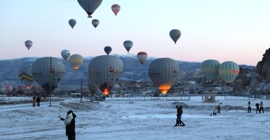Tourists are seen below hot air balloons, Cappadocia, central Türkiye, Feb. 23, 2025. (AA Photo)
