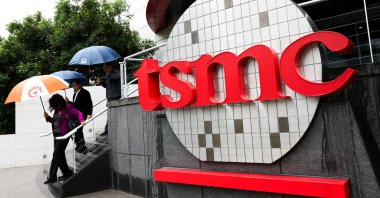 People walk beside a logo outside the Taiwan Semiconductor Manufacturing Company (TSMC) Museum of Innovation at its headquarters, Hsinchu, Taiwan, Nov. 21, 2024. (AFP Photo)