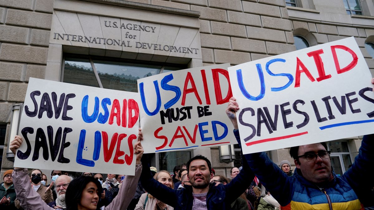 People hold placards, as the USAID building sits closed to employees after a memo was issued advising agency personnel to work remotely, Washington, D.C., U.S., Feb. 3, 2025. (Reuters Photo)