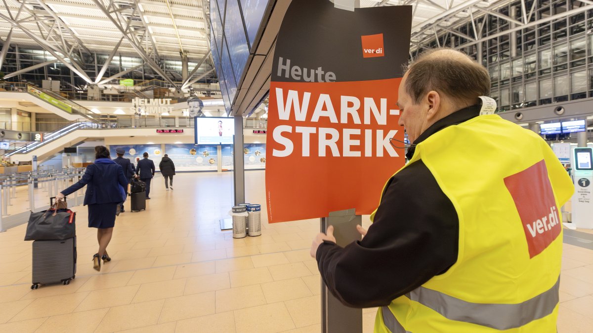A Verdi representative hangs up a poster with the words &quot;Warning strike&quot; in a terminal at Hamburg Airport, Hamburg, Germany, Feb. 12, 2025. (AP Photo)