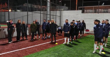 Rana Özdemir (C) poses for a photo with Hanzadespor club players on a football pitch in Urla, Izmir, Türkiye, Feb. 2, 2025. (AA Photo)