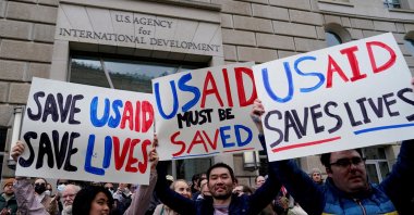 People hold placards, as the USAID building sits closed to employees after a memo was issued advising agency personnel to work remotely, Washington, D.C., U.S., Feb. 3, 2025. (Reuters Photo)