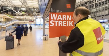 A Verdi representative hangs up a poster with the words &quot;Warning strike&quot; in a terminal at Hamburg Airport, Hamburg, Germany, Feb. 12, 2025. (AP Photo)