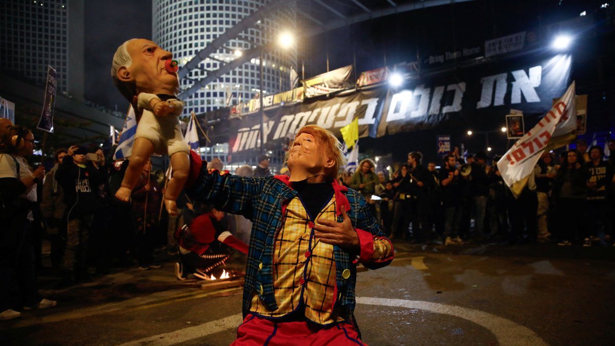 A demonstrator wearing a mask representing U.S. President Donald Trump holds an effigy of Israeli Prime Minister Benjamin Netanyahu during protests, Tel Aviv, Israel, March 8, 2025. (Reuters Photo)