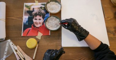 Serap Lokmacı, a painter who works with sand for her drawings, makes a portrait of Hungarian woman Katalin Kollar using ashes from her cremation in Ürgüp, Nevşehir, Türkiye, Feb. 27, 2025. (Reuters Photo)