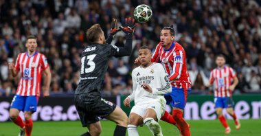 Real Madrid&#039;s Kylian Mbappe (C) is challenged by Atletico Madrid&#039;s Jose Gimenez (R) and Atletico Madrid&#039;s goalkeeper Jan Oblak during the UEFA Champions League Round of 16 first leg football match at the Santiago Bernabeu stadium, Madrid, Spain, March 4, 2025. (AFP Photo)