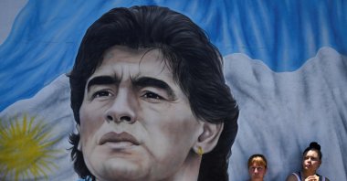Members of social organizations stand next to a mural depicting late Argentine football star Diego Maradona during a protest at Pueyrredon Bridge, Buenos Aires, Argentina, Dec. 2, 2022. (AFP Photo)