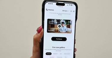 A photo illustration shows a mobile phone displaying an introduction screen for the AI assistant tool Manus, released by Chinese startup Butterfly Effect, Beijing, China, March 11, 2025. (AFP Photo) 