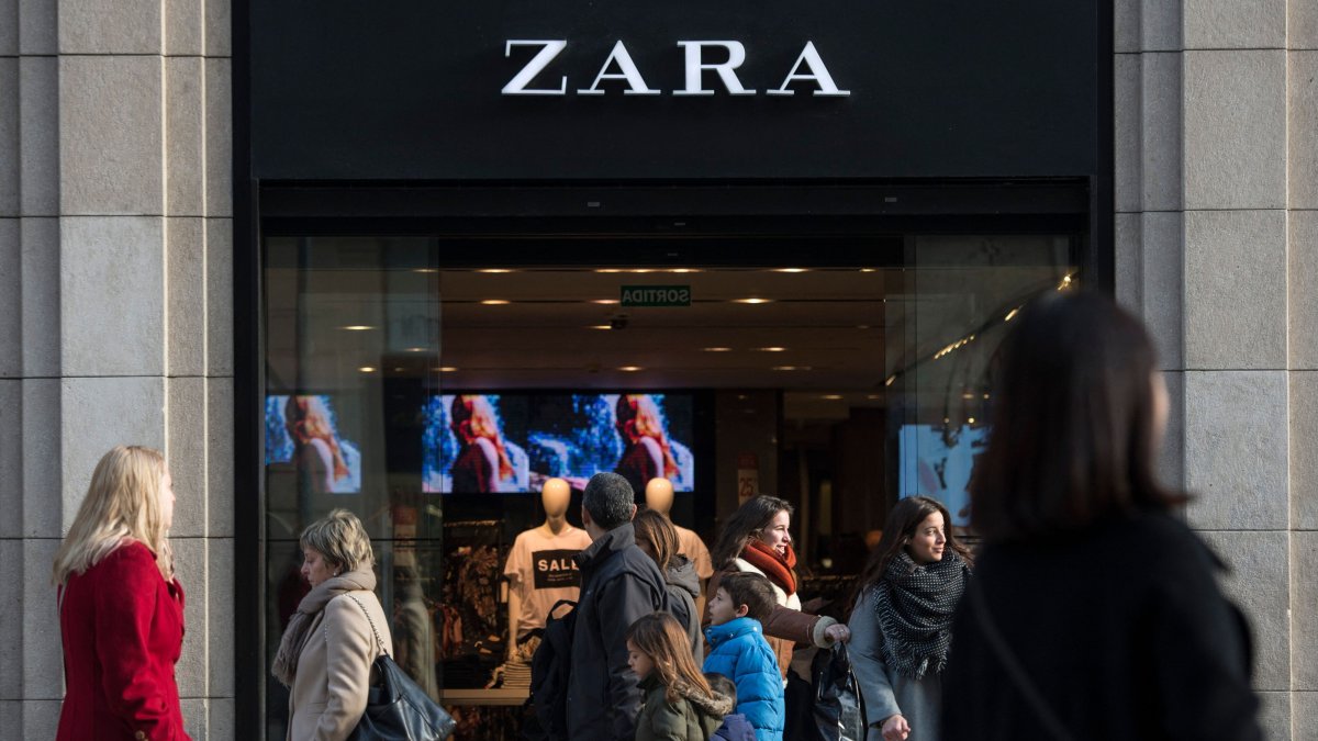 People pass by a Zara shop announcing discounts on the first day of the winter sales, Barcelona, Spain, Jan. 7, 2017. (AFP Photo)