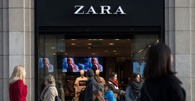 People pass by a Zara shop announcing discounts on the first day of the winter sales, Barcelona, Spain, Jan. 7, 2017. (AFP Photo)