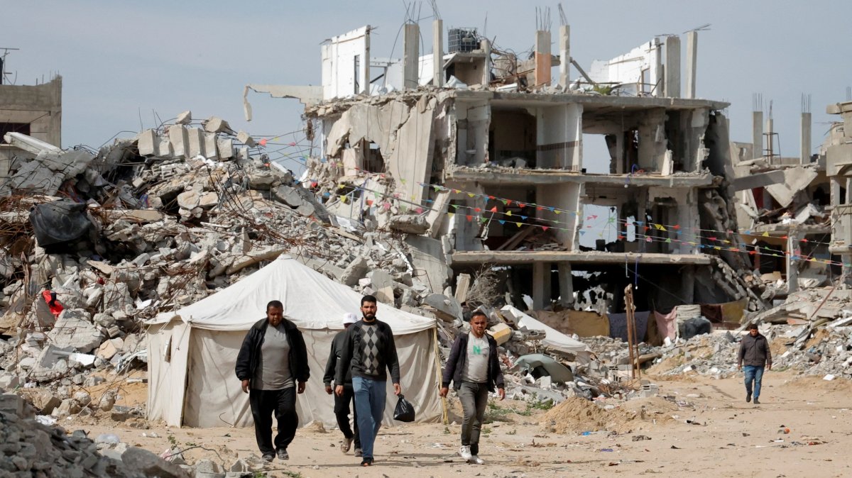 Palestinian men walk near the rubble of houses destroyed by Israel in Rafah, southern Gaza Strip, Palestine, March 13, 2025. (Retuers Photo)