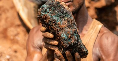 Dela wa Monga, an artisanal miner, holds a cobalt stone at the Shabara artisanal mine near Kolwezi, DRC, Oct. 12, 2022. (AFP Photo)
