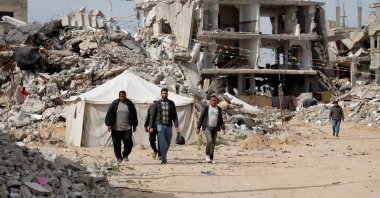 Palestinian men walk near the rubble of houses destroyed by Israel in Rafah, southern Gaza Strip, Palestine, March 13, 2025. (Retuers Photo)