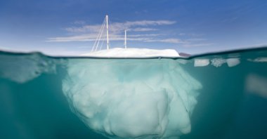 The Greenlandia expedition&#039;s sailing boat "Kamak" sails between icebergs released by glaciers around Milne Land in the Scoresby Sound Fjord, Greenland, Denmark, Aug. 15, 2023. (AFP photo)