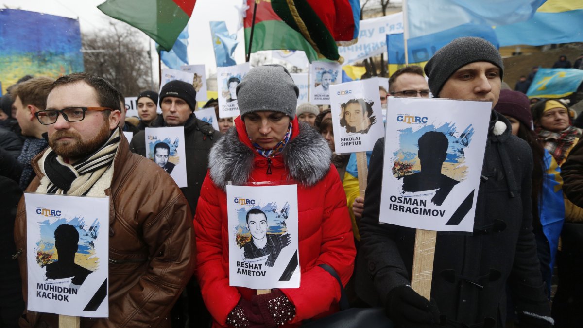 Ukrainian and Crimean Tatar activists hold portraits with the names of victims of the Russian annexation of Crimea, Kyiv, Ukraine, Feb. 26, 2017. (AP Photo)