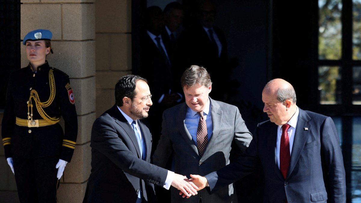 The Greek Cypriots leader Nikos Christodoulides (L) and Turkish Cypriot President Ersin Tatar (R) shake hands after a meeting in the presence of U.N. Cyprus representative Colin Stewart (C), Lefkoşa (Nicosia), island of Cyprus, Jan. 20, 2025. (Reuters Photo)