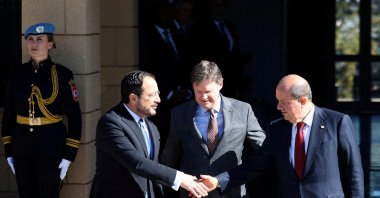 The Greek Cypriots leader Nikos Christodoulides (L) and Turkish Cypriot President Ersin Tatar (R) shake hands after a meeting in the presence of U.N. Cyprus representative Colin Stewart (C), Lefkoşa (Nicosia), island of Cyprus, Jan. 20, 2025. (Reuters Photo)