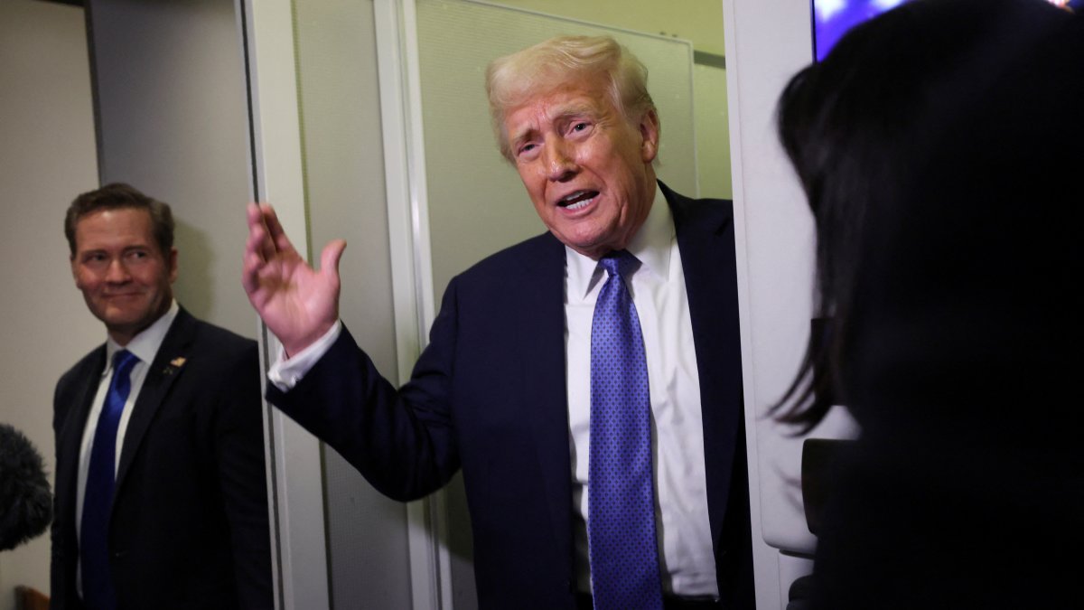 U.S. President Donald Trump speaks to reporters, watched by National Security Advisor Mike Waltz, aboard Air Force One on his return to Washington, D.C., U.S., March 16, 2025. (Reuters Photo)
