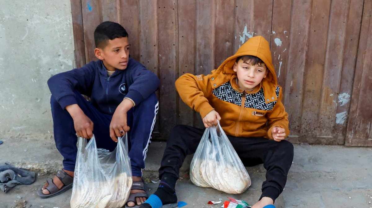 Palestinian boys rest after receiving bread from a bakery, in Rafah, in the southern Gaza Strip, Palestine, March 13, 2025. (Reuters Photo)