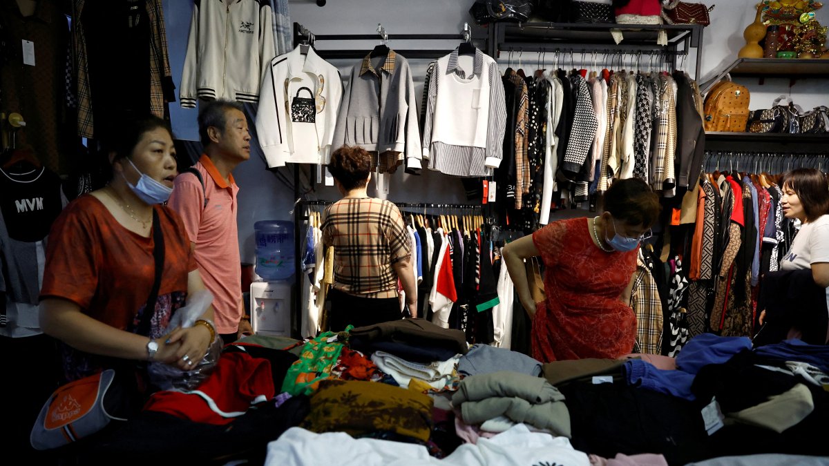 Customers shop for clothes at a stall inside a wholesale market, Beijing, China, Sept. 8, 2023. (Reuters Photo)