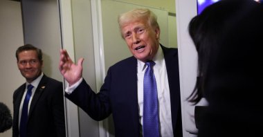 U.S. President Donald Trump speaks to reporters, watched by National Security Advisor Mike Waltz, aboard Air Force One on his return to Washington, D.C., U.S., March 16, 2025. (Reuters Photo)