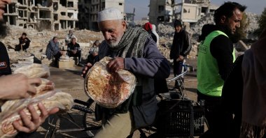 A man holds a bag of bread after receiving it from a Turkish humanitarian NGO at al-Yarmouk Palestinian refugee camp, in Damascus, Syria, Dec. 20, 2024. (Reuters Photo)