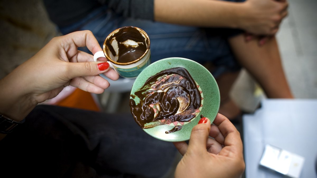 A woman practices Turkish coffee fortune telling at a street cafe in Istanbul, Türkiye, Sept. 25, 2006. (Reuters Photo)