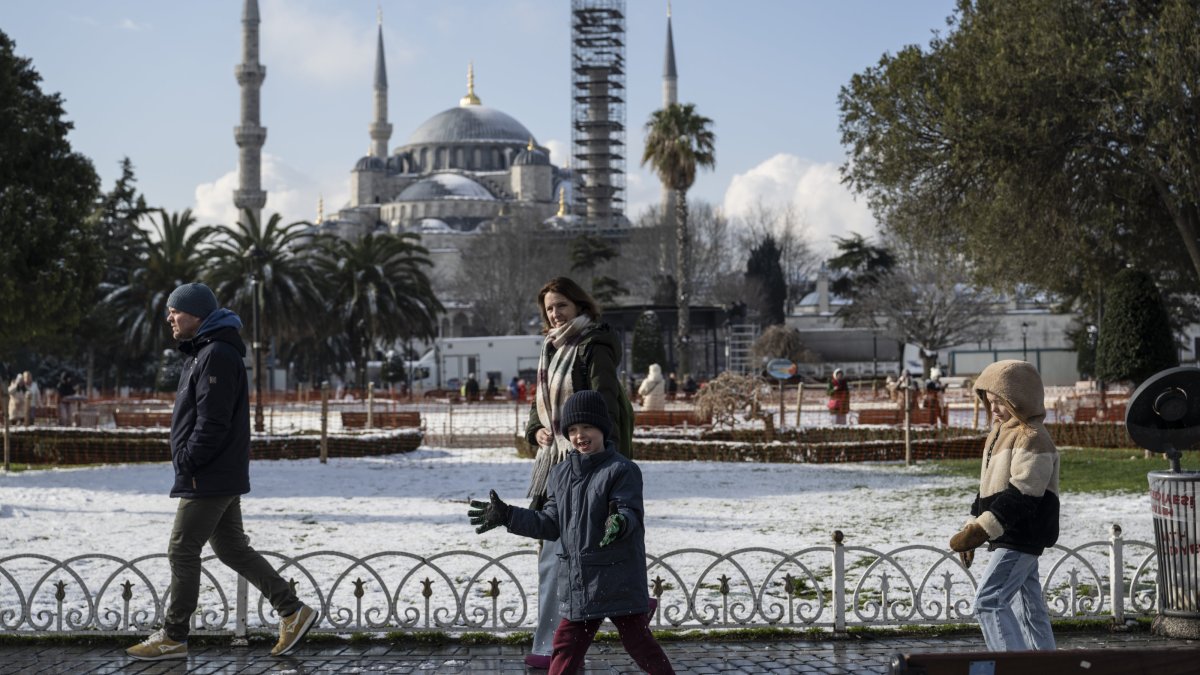 A family walks in the Sultanahmet neighborhood, with the historic Blue Mosque in the background, Istanbul, Türkiye, Feb. 23, 2025. (AA Photo)
