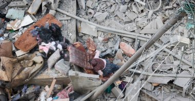 A woman searches through the rubble of her home, destroyed in an Israeli strike, for salvageable items at the Nuseirat refugee camp, Gaza Strip, Palestine, March 18, 2025. (AFP Photo)