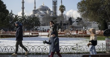 A family walks in the Sultanahmet neighborhood, with the historic Blue Mosque in the background, Istanbul, Türkiye, Feb. 23, 2025. (AA Photo)