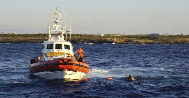 Italian Coast guards intercept a man as they tried to swim to the island of Lampedusa, southern Italy, Aug. 20, 2019. (AP Photo)