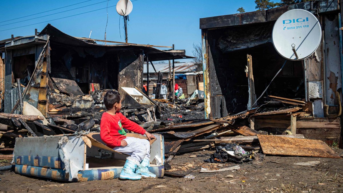 A child sits at a burnt house destroyed in a night fire in a roma settlement in Velky Saris, near Presov, Slovakia, March 20, 2025. (AFP Photo)