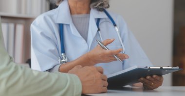 A doctor discusses test results with a patient during a medical consultation. (Shutterstock Photo) 