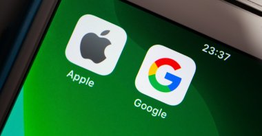 Apple and Google brand logos are seen together on a green iPhone screen in a photo taken in Kumamoto, Japan, May 7, 2020. (Shutterstock Photo)
