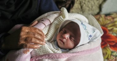 Ella Osama Abu Dagga, 25 days old, is held by her great-aunt Suad Abu Dagga after she was pulled from the rubble earlier following an Israeli army airstrike that killed her parents and brother in Khan Younis, Gaza Strip, Palestine, March 20, 2025. (AP Photo)