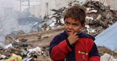 A boy looks on as he eats at a camp sheltering displaced Palestinians set up at a landfill in the Yarmuk area, Gaza City, Palestine, March 20, 2025. (AFP Photo)