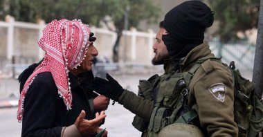 A Palestinian Muslim man heading to the Al-Aqsa Mosque Complex talks with an Israeli border guard as he crosses a checkpoint, Bethlehem, West Bank, Palestine, March 21, 2025. (AFP Photo)