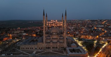 The illuminated mahya reading "Family is the foundation of society" hangs the minarets of Selimiye Mosque, Edirne, Türkiye, March 17, 2025. (IHA Photo)