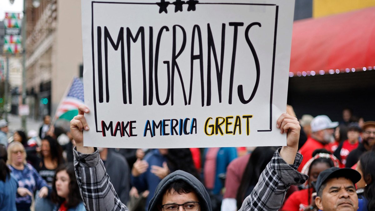 An immigrant rights supporter holds a sign reading &#039;Immigrants Make America Great&#039; before marching downtown during a &#039;March for Dignity&#039;, in Los Angeles, California, U.S., March 1, 2025. (AFP Photo)