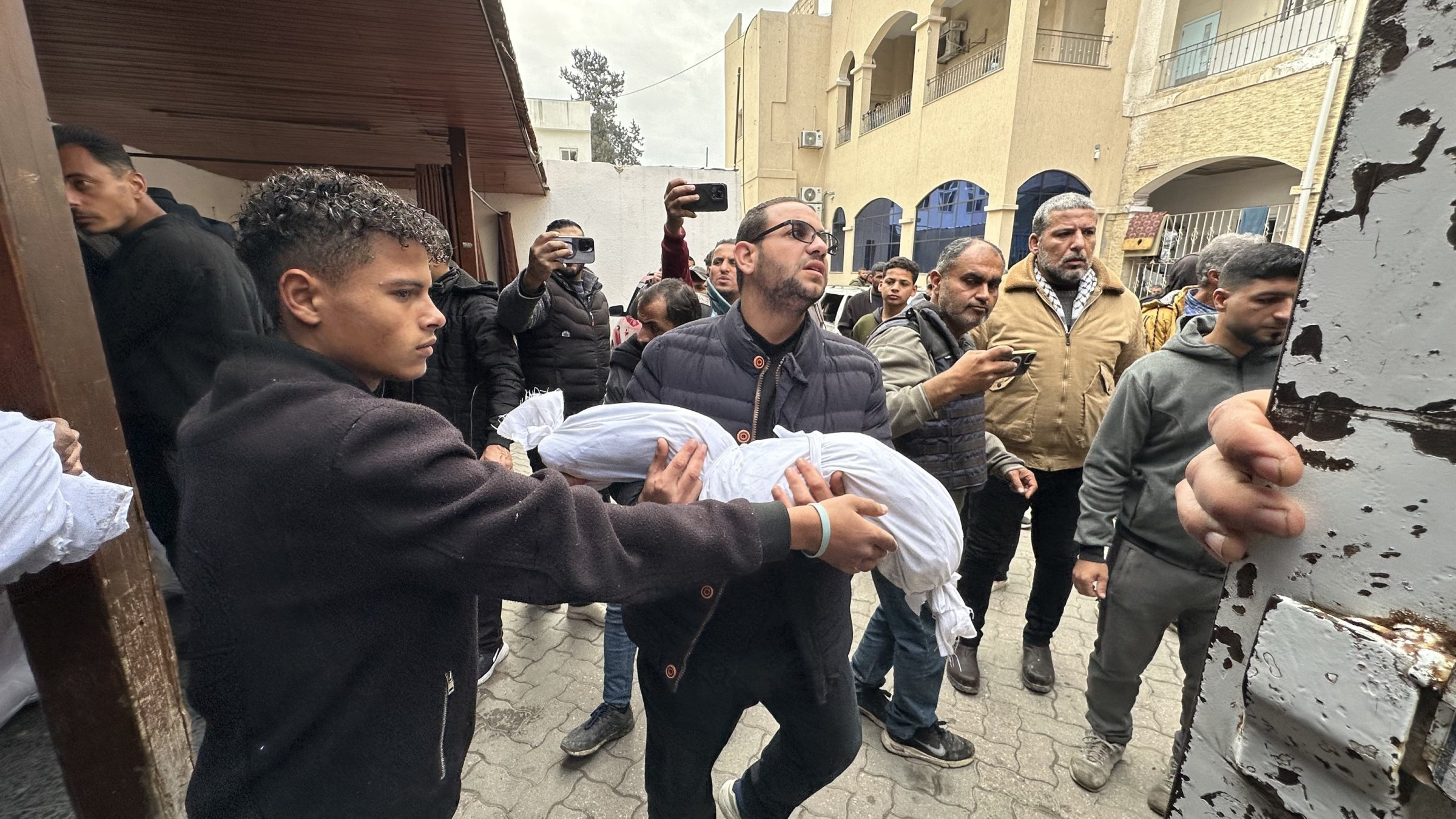 A Palestinian man carries the body of a child killed in an Israeli airstrike on a residential building in eastern Tuffah district, Gaza Strip, March 22, 2025. (AA Photo)