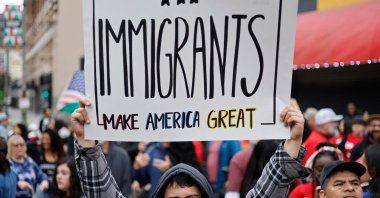 An immigrant rights supporter holds a sign reading &#039;Immigrants Make America Great&#039; before marching downtown during a &#039;March for Dignity&#039;, in Los Angeles, California, U.S., March 1, 2025. (AFP Photo)