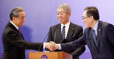 Chinese Foreign Minister Wang Yi (L) and South Korean Foreign Minister Cho Tae-yul shake hands as Japanese Foreign Minister Takeshi Iwaya smiles during a joint press conference, in Tokyo, Japan, March 22, 2025. (Reuters Photo)