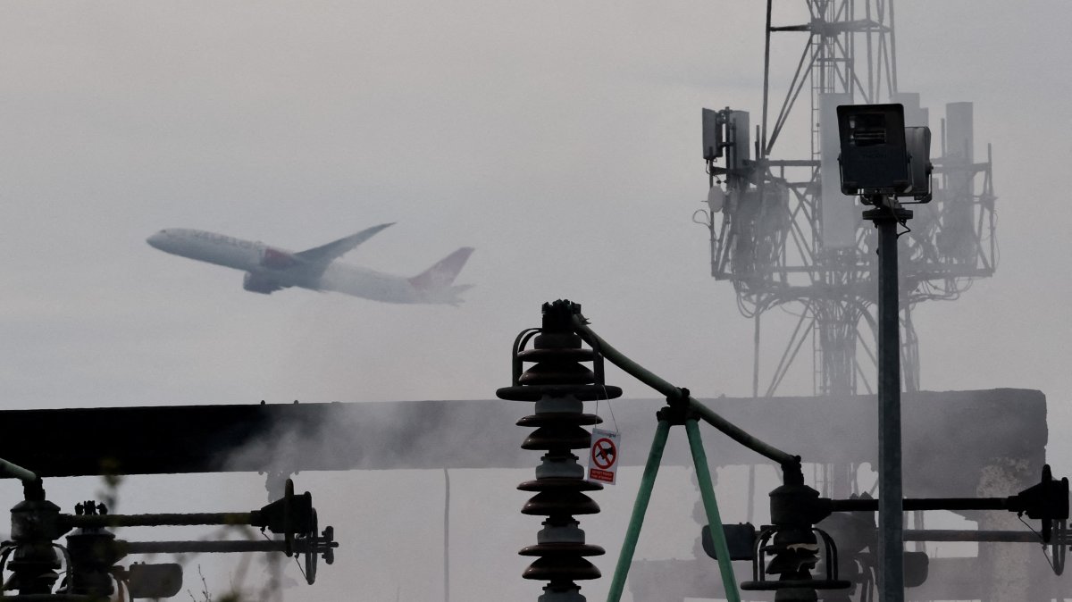 A plane takes off, as smoke rises from an area of an electrical substation a day after it caught fire and wiped out power at Heathrow International Airport, near London, Britain, March 22, 2025. (Reuters Photo)